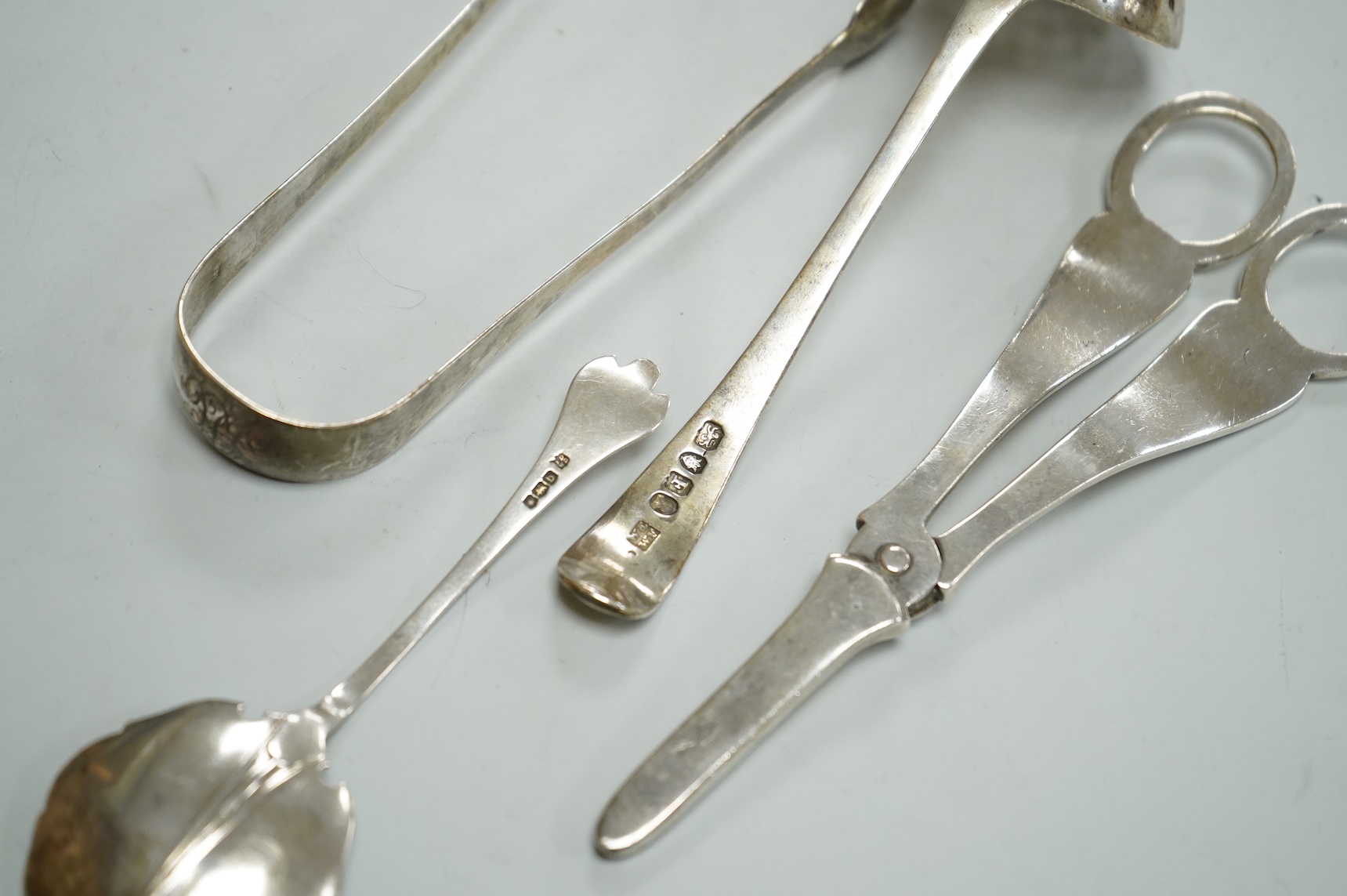 A pair of George V silver grape shears, Josiah Williams & Co, London, 1912, 16.2cm, together with a George III silver Old English pattern sifter spoon, Eley & Fearn, London, 1801, a similar pair of sugar tongs, London, 1